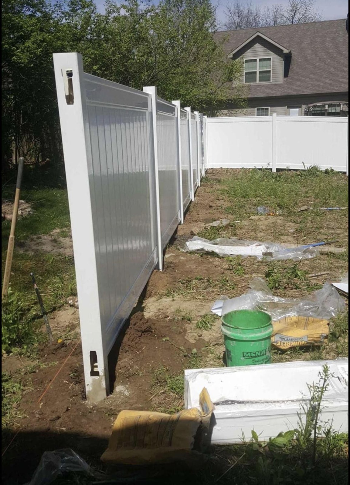 White vinyl fence run: A view down the fence line during installation.