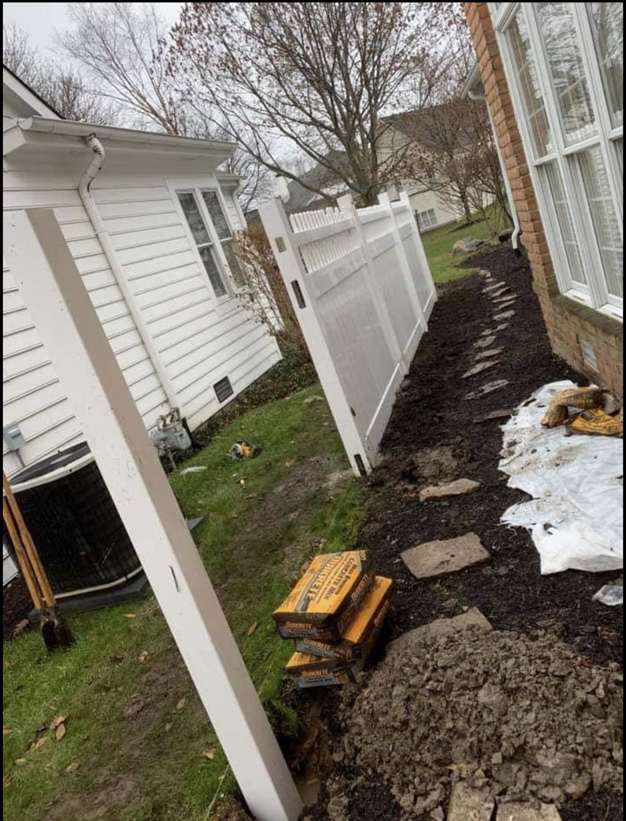 Vinyl side-yard installation: White panels fitted along a narrow side yard.